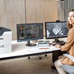 Femme dans un bureau à côté de l'imprimante Xerox® VersaLink® C620